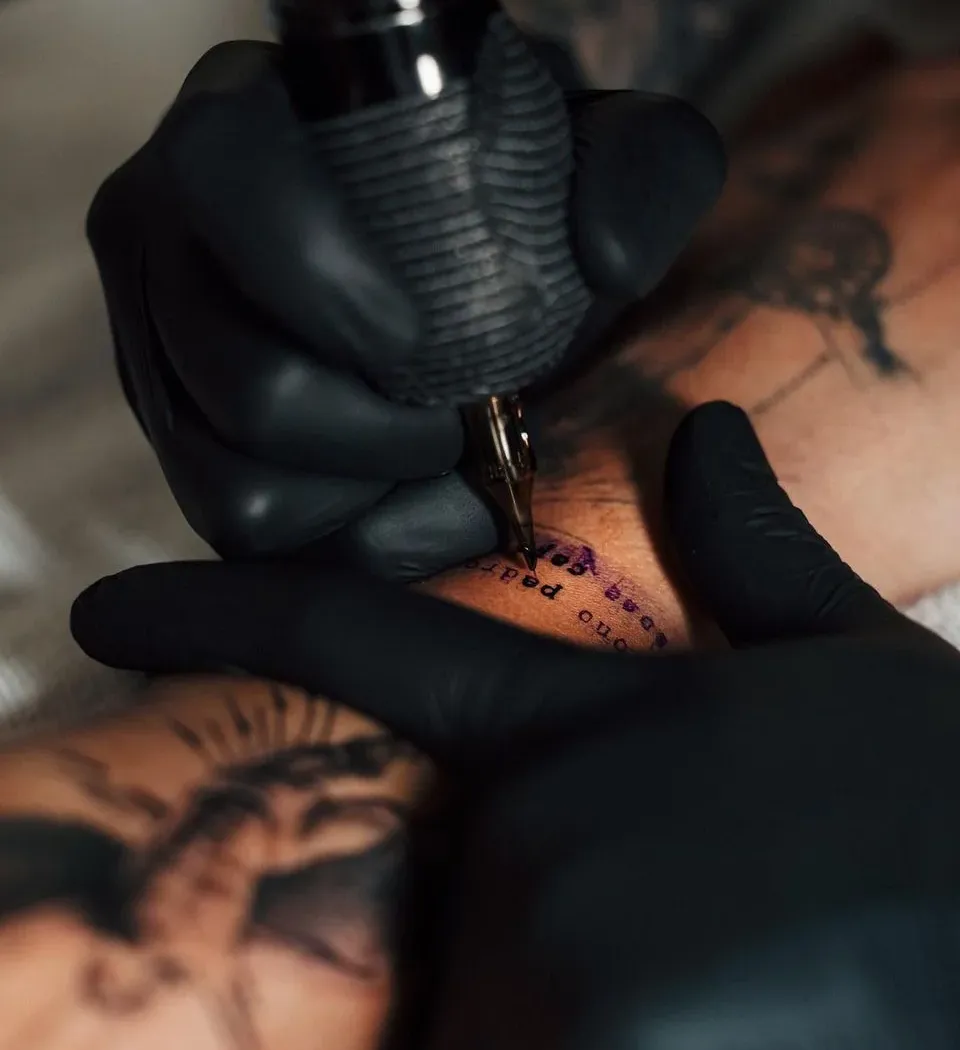 Arjun, lead tattoo artist focused on crafting a custom tattoo in the studio